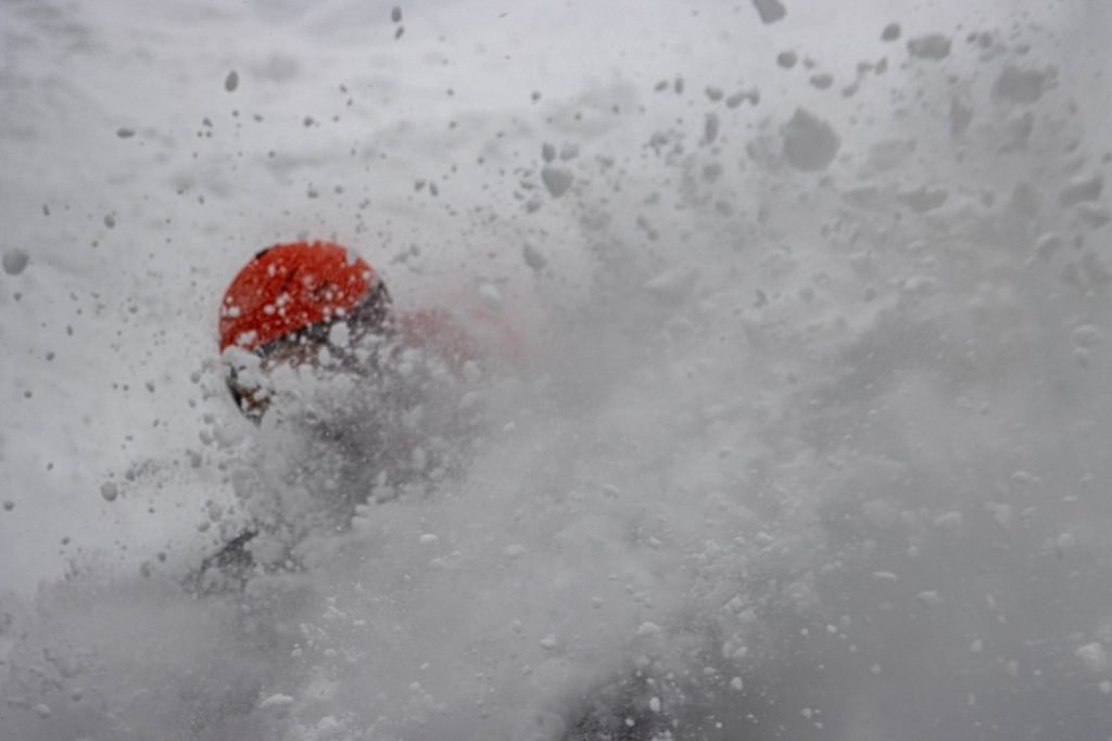 A backcountry skier in a powder “cloud”, while skiing in BC.