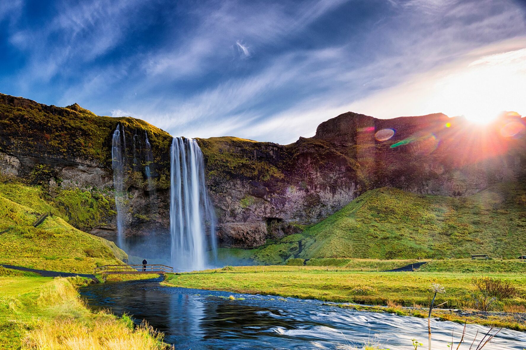 A hiker appreciating the beauty of the Seljalandsfoss in Iceland.