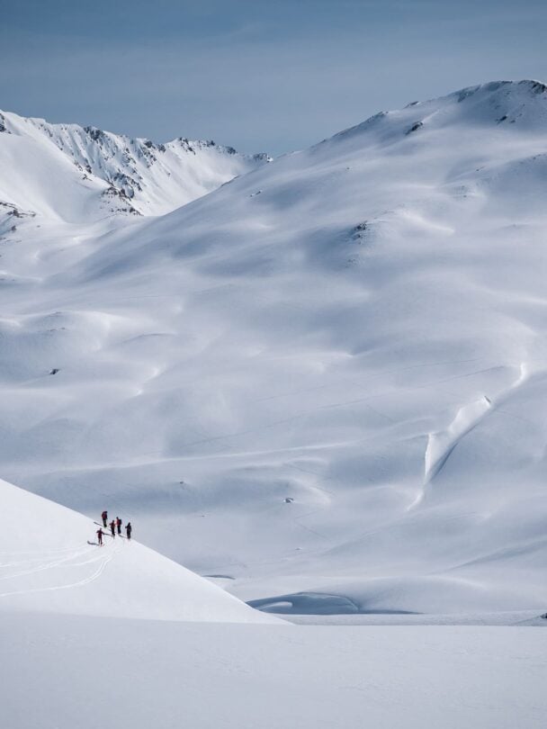 Three backcountry skiers skinning up a slope in Silvretta, Austria.