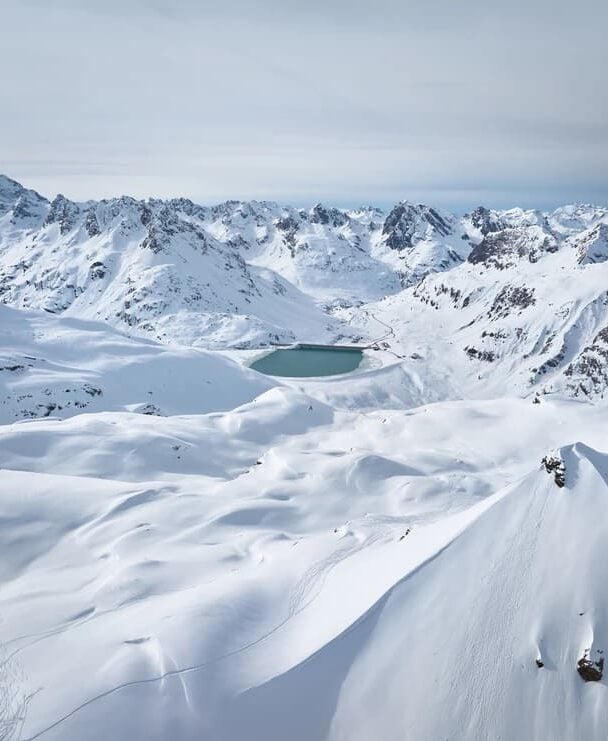 Three backcountry skiers skinning up a slope in Silvretta, Austria.
