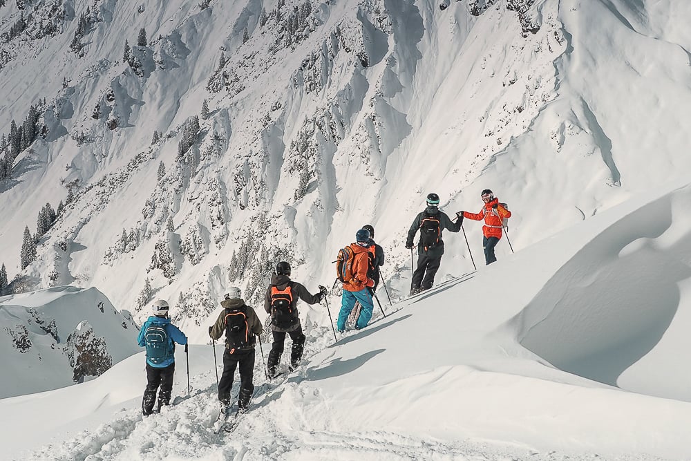 Tourers exploring St. Anton with a beautiful landscape in the background.