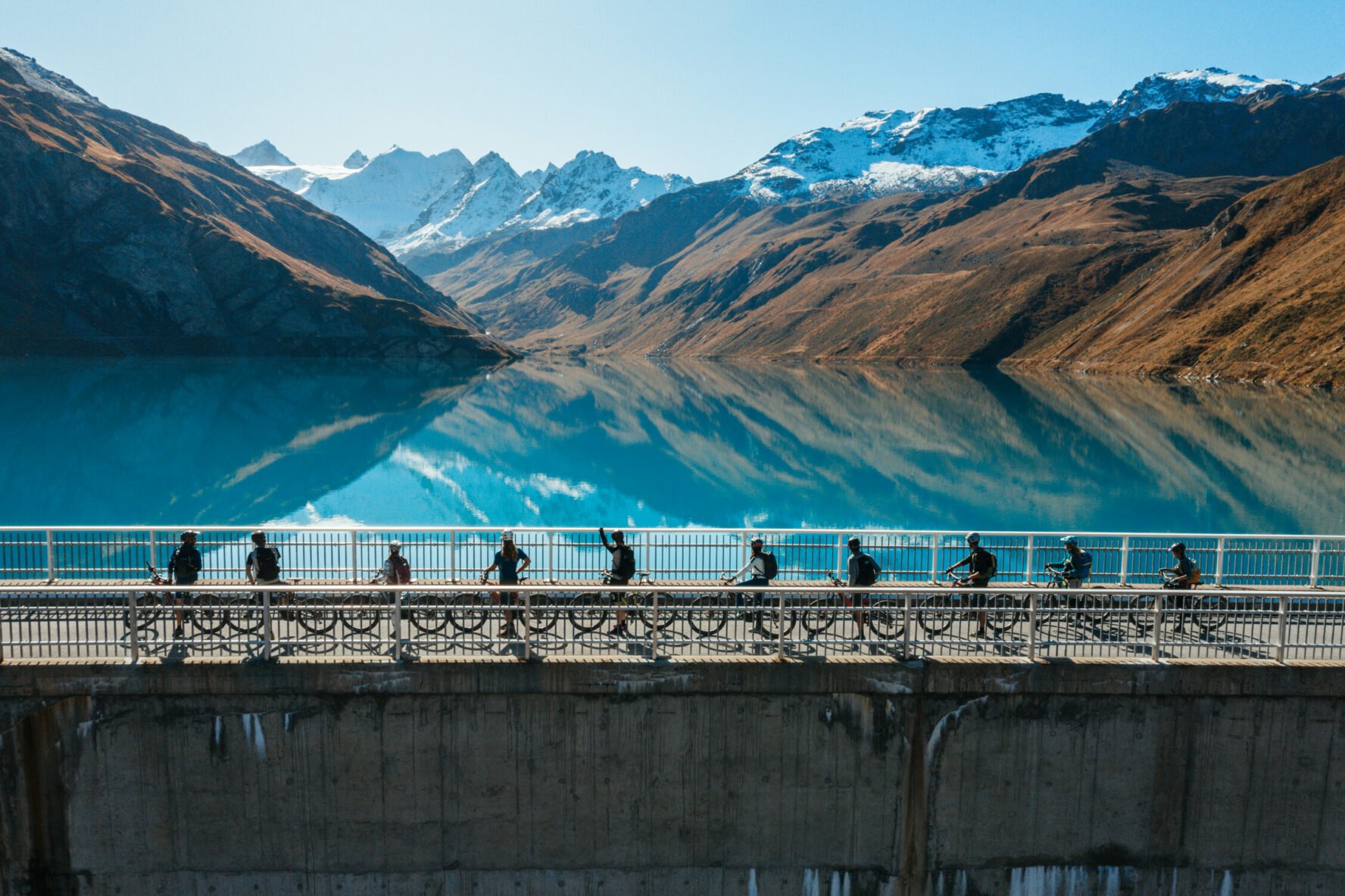 Riders on top of a dam in the Swiss Alps.