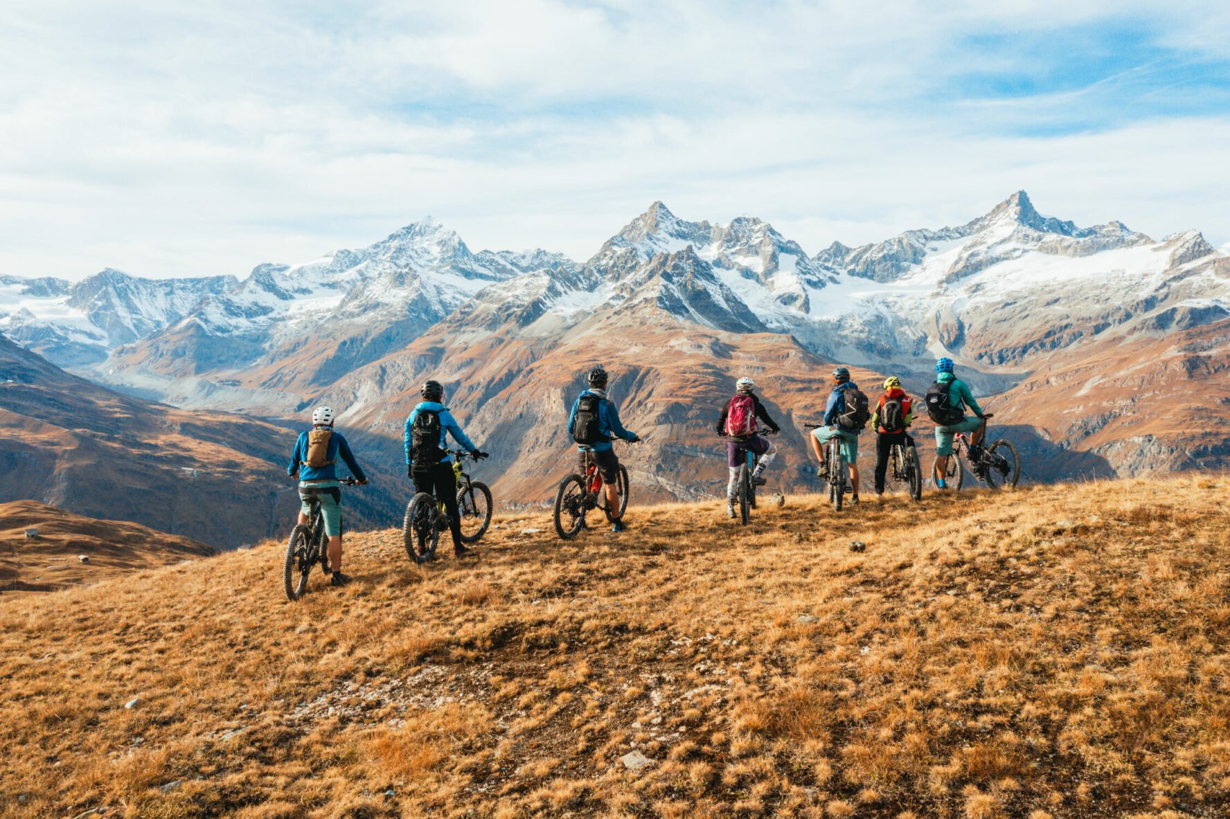 E-mountain bikers enjoying views of glaciated peaks inn the Swiss Alps.