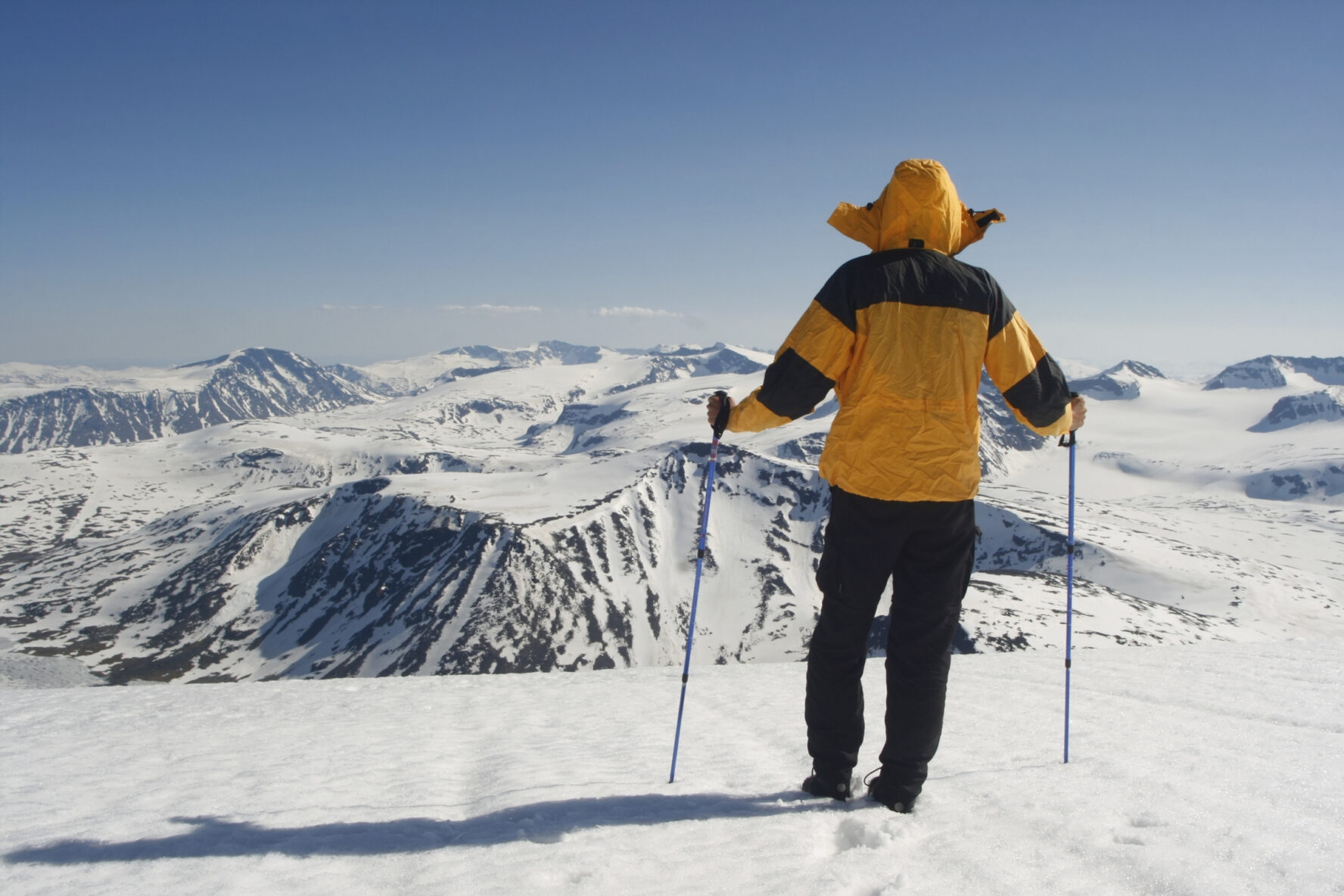 Backountry skiers standing atop Glittertind, the second highest mountain in Norway.