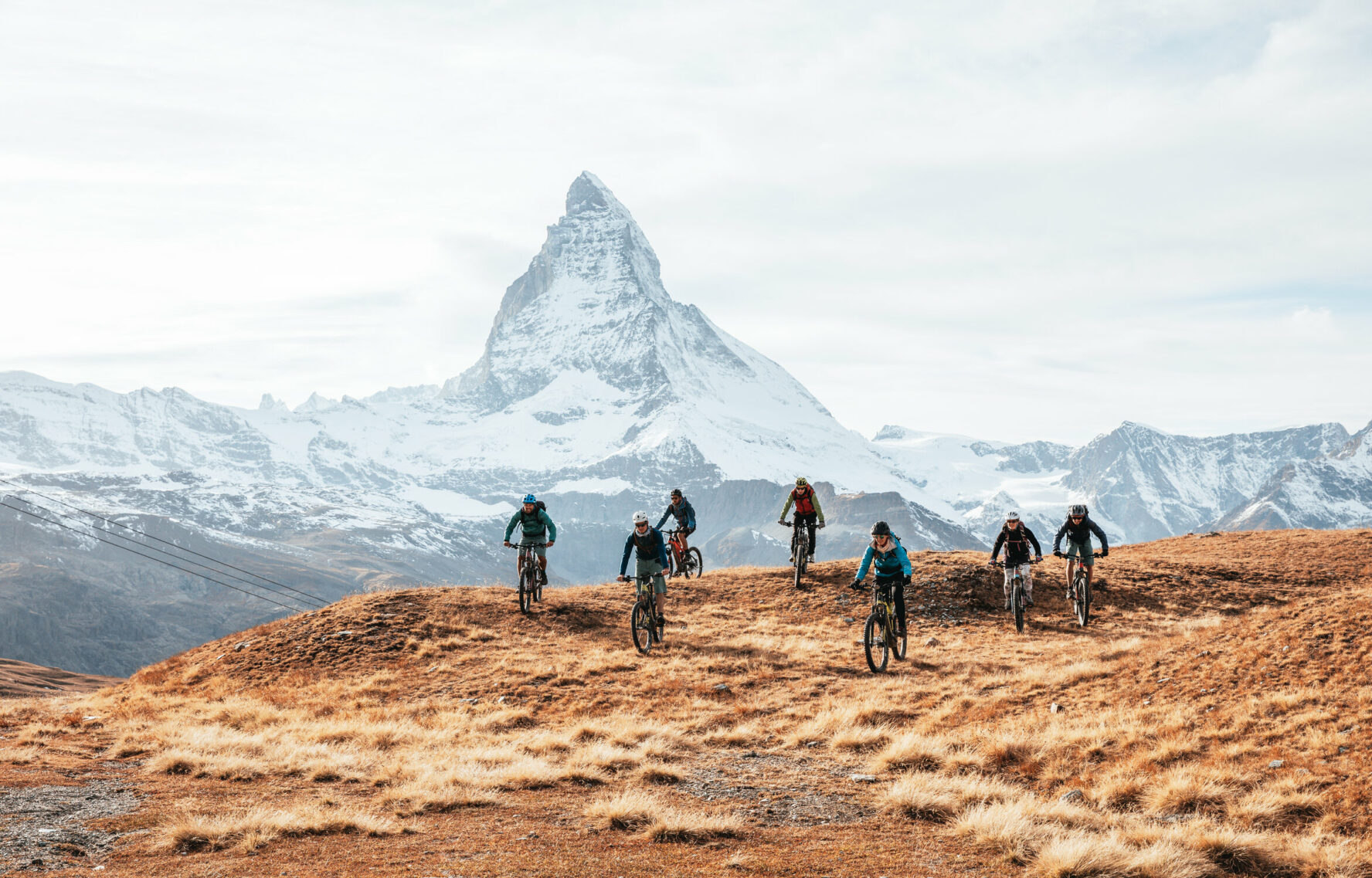 E-mountain bikers near Matterhorn, Swiss Alps.