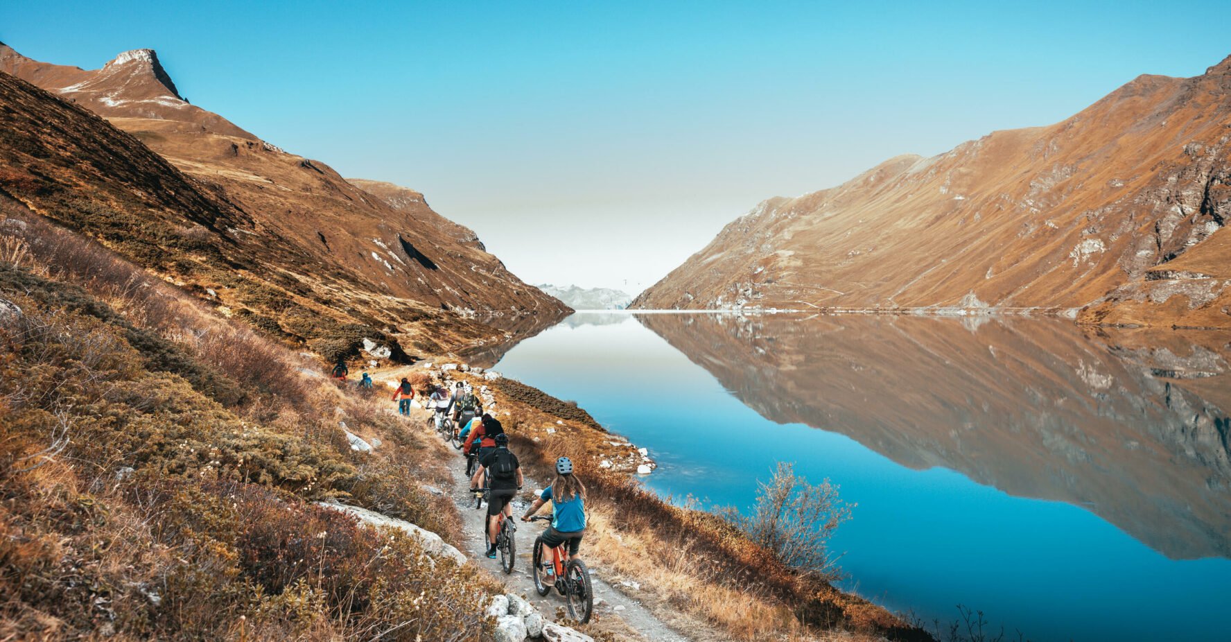 E-mountain bikers on a gravel road, part of their Haute Route tour.