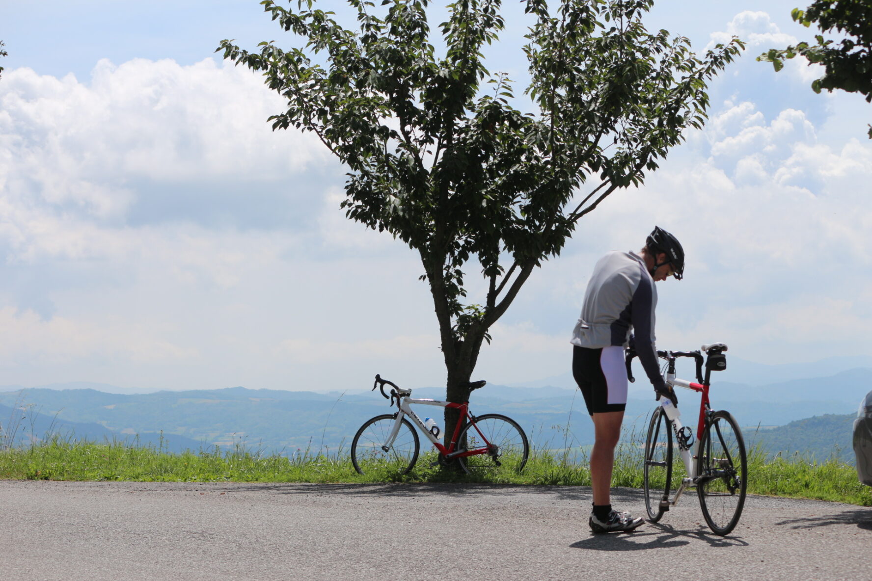 One cyclist in Sardinia standing at a viewpoint
