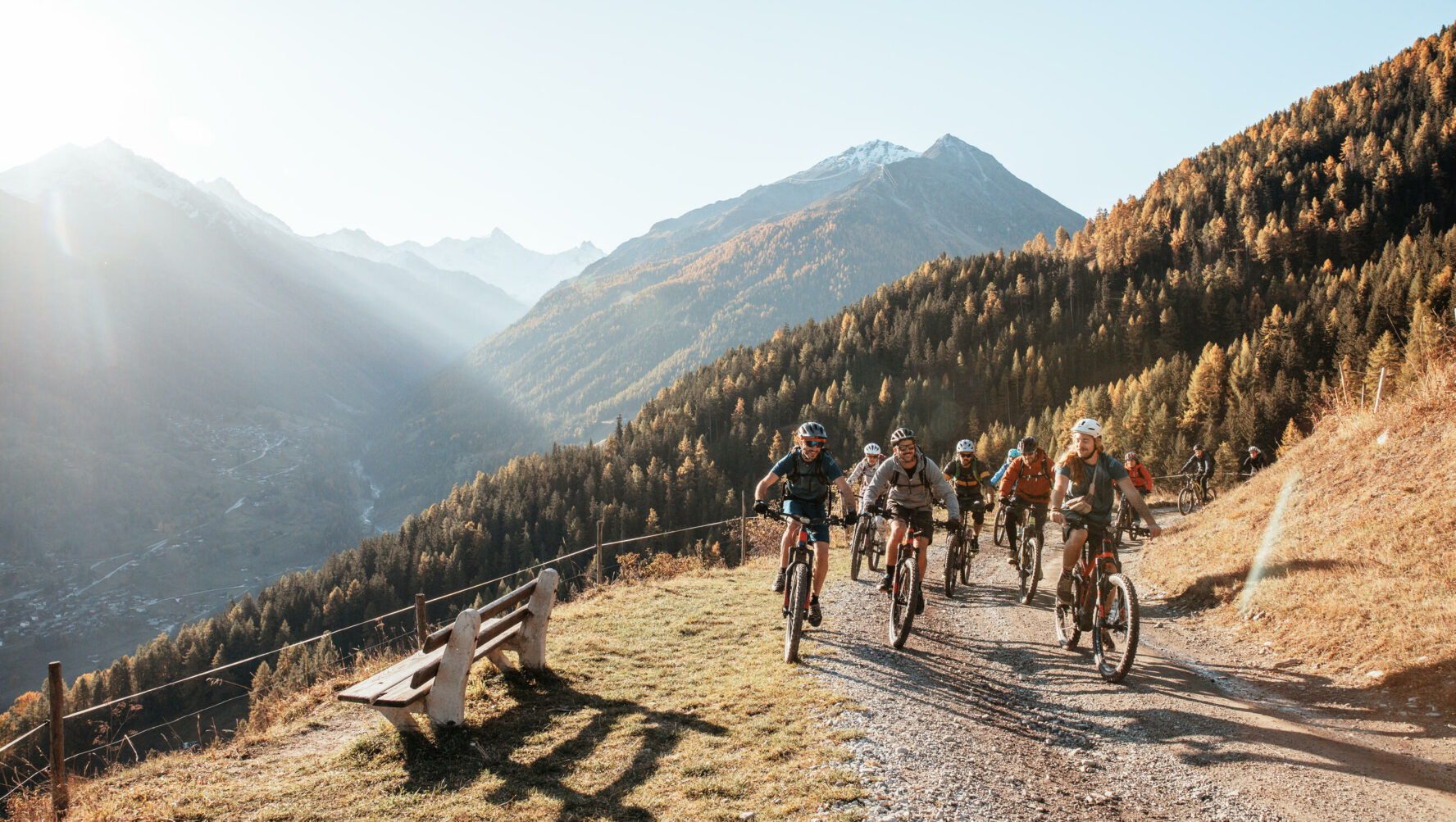 E-mountain bikers riding on a scenic gravel road in the Swiss Alps.