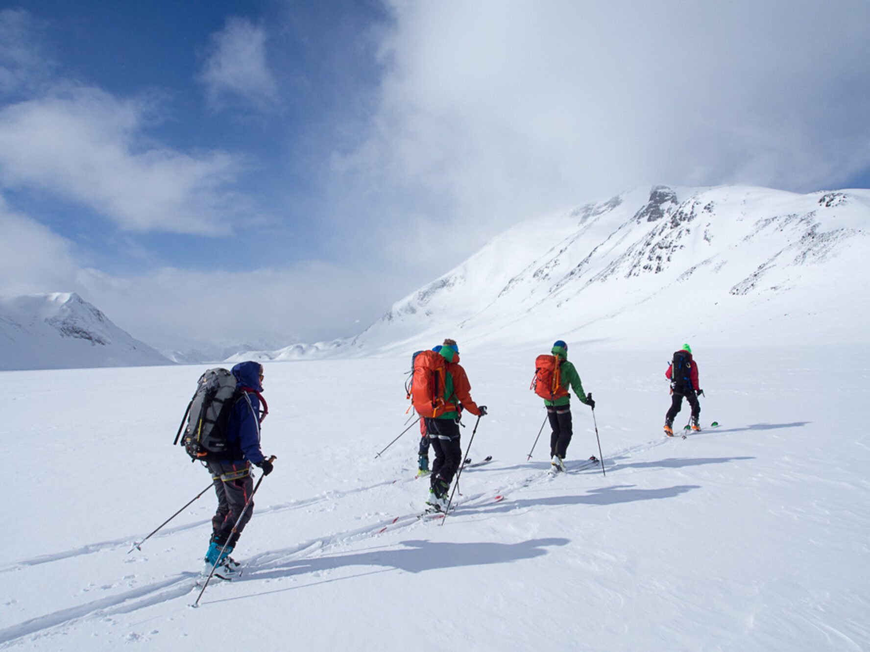 Backcountry skiers going through the snowy expanse in the Jotunheimen National Park.