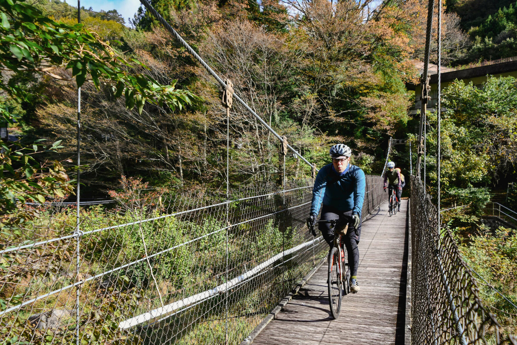 A cyclist crossing a suspension bridge in Japan.