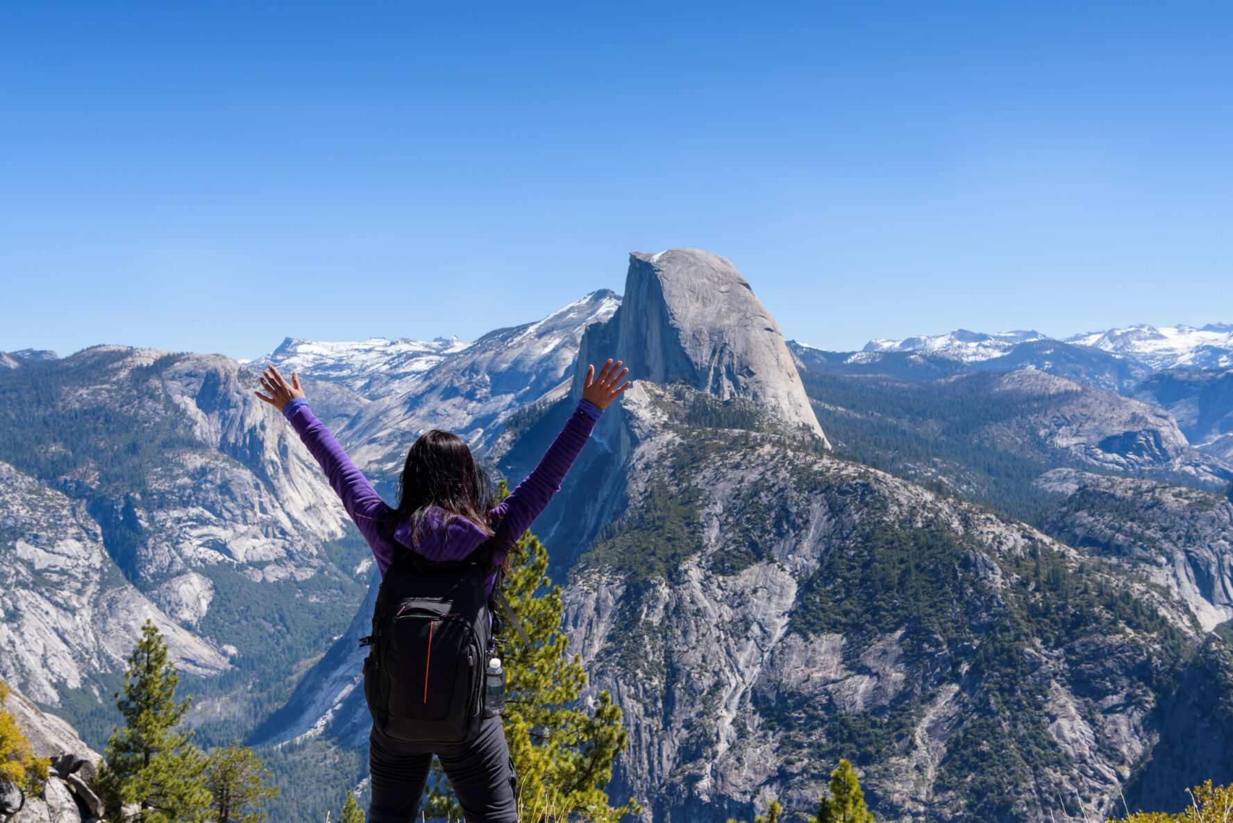 Happy hiker at the Glacier Point, with incredible panoramic views of Half Dome and other peaks.