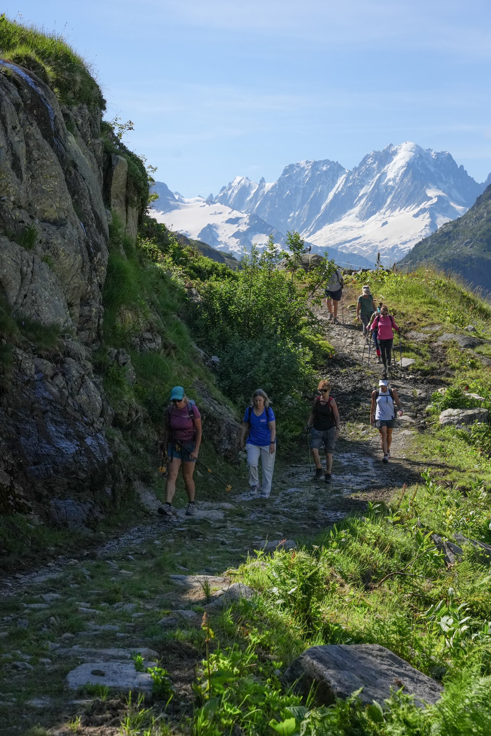 Group of women hiking on a trail with Swiss mountains in the background