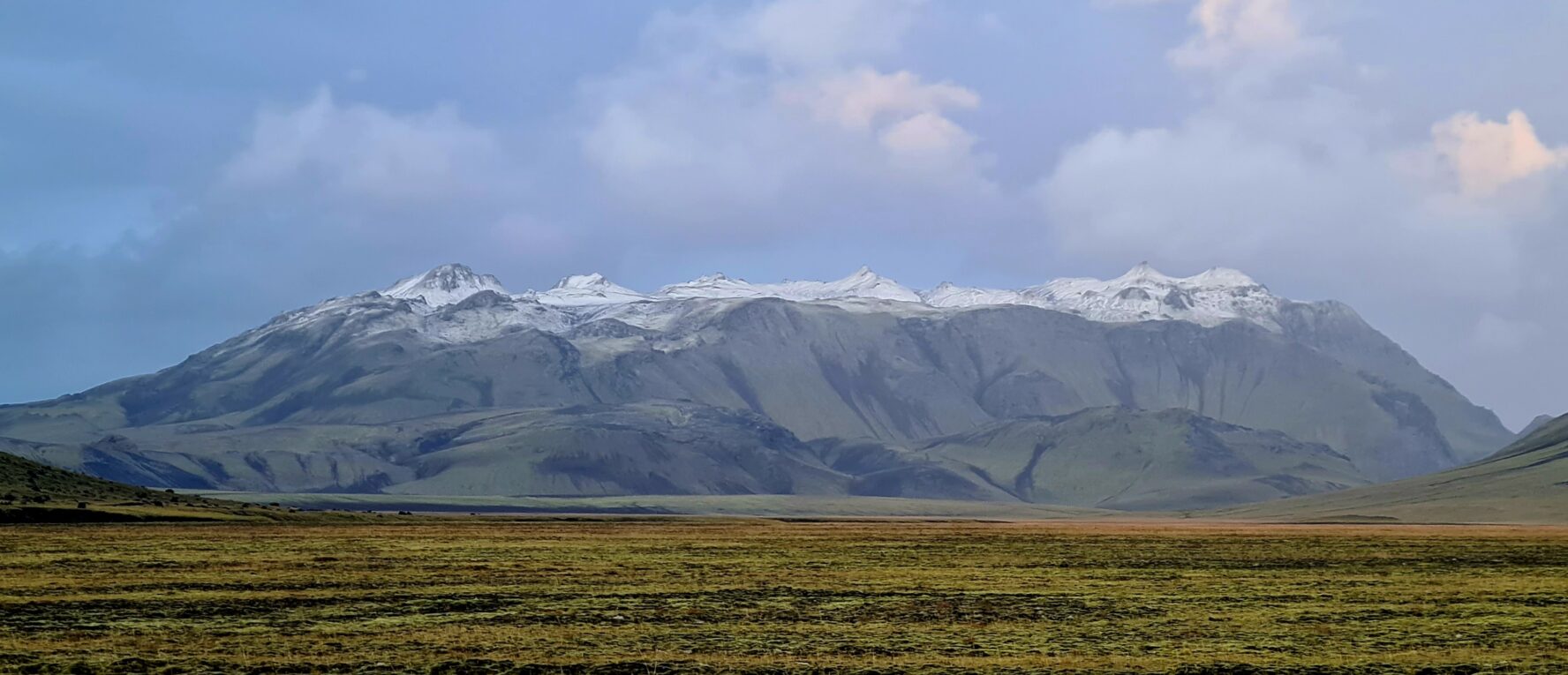 A plain and a snowy mountain in the distance, in the Icelandic Highlands.