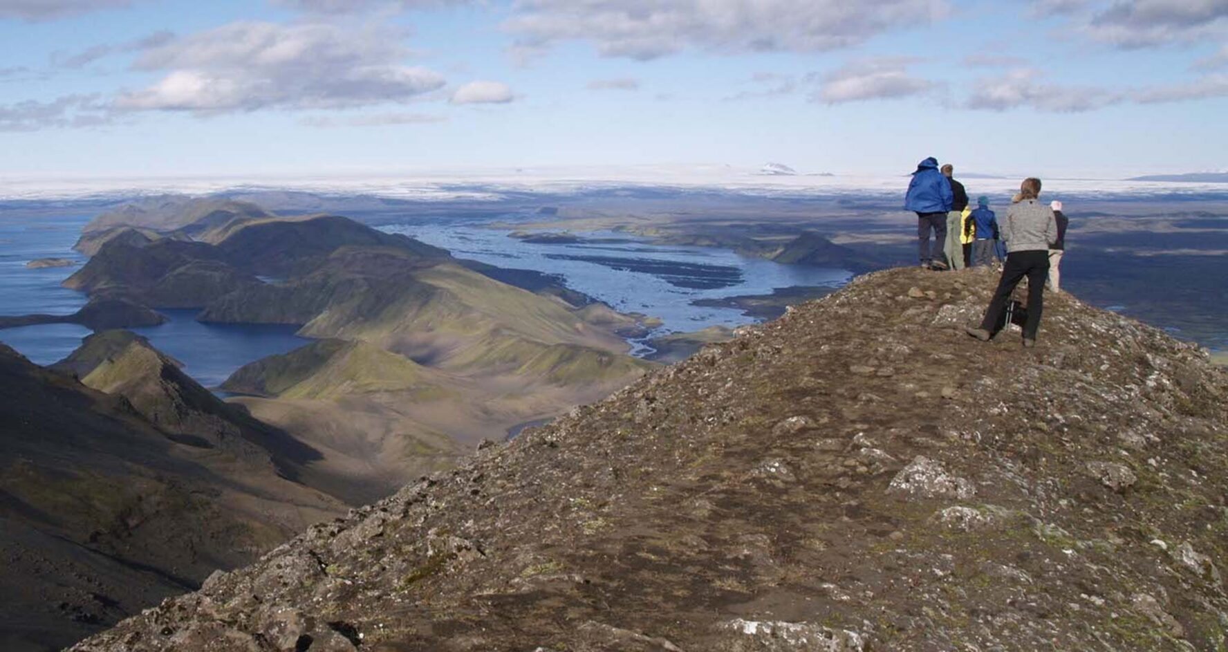 Hikers admiring the view of the Icelandic Highlands from the Sveinstindur peak.