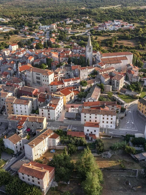 A cyclist pointing at the medieval hilltop town of Motovun while located in the verdant Mirna Valley in Istria, Croatia.