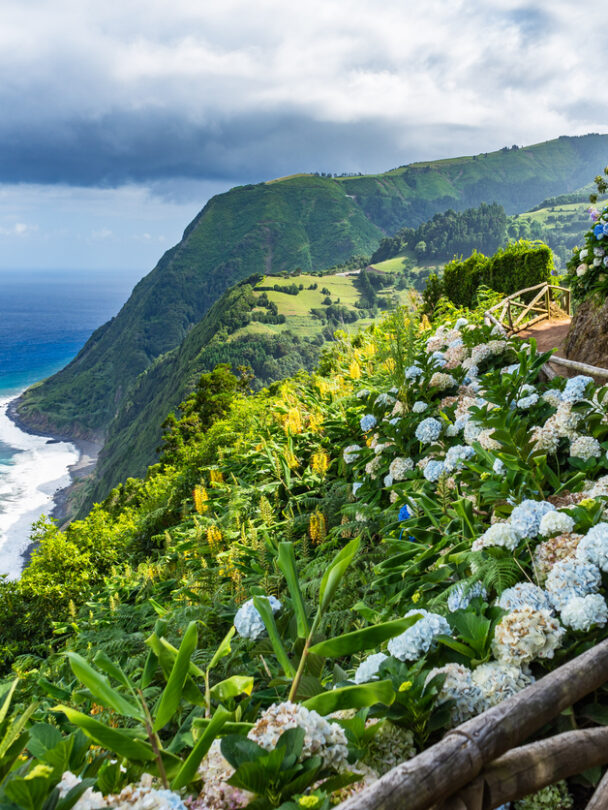 Hiker in a red jacket at the caldera on São Miguel island in the Azores