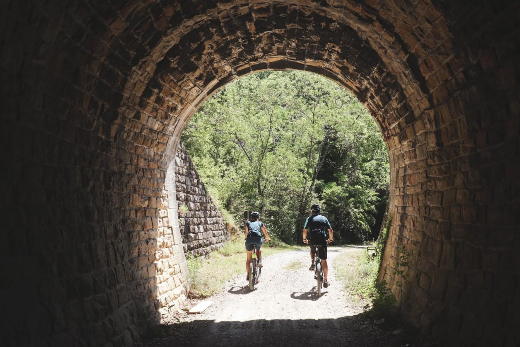 Cyclist going out of a tunnel along an old railroad Parenzana in Istria, Croatia.