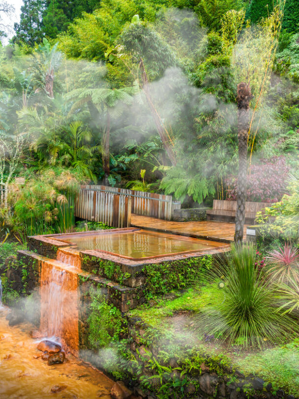 Hiker in a red jacket at the caldera on São Miguel island in the Azores