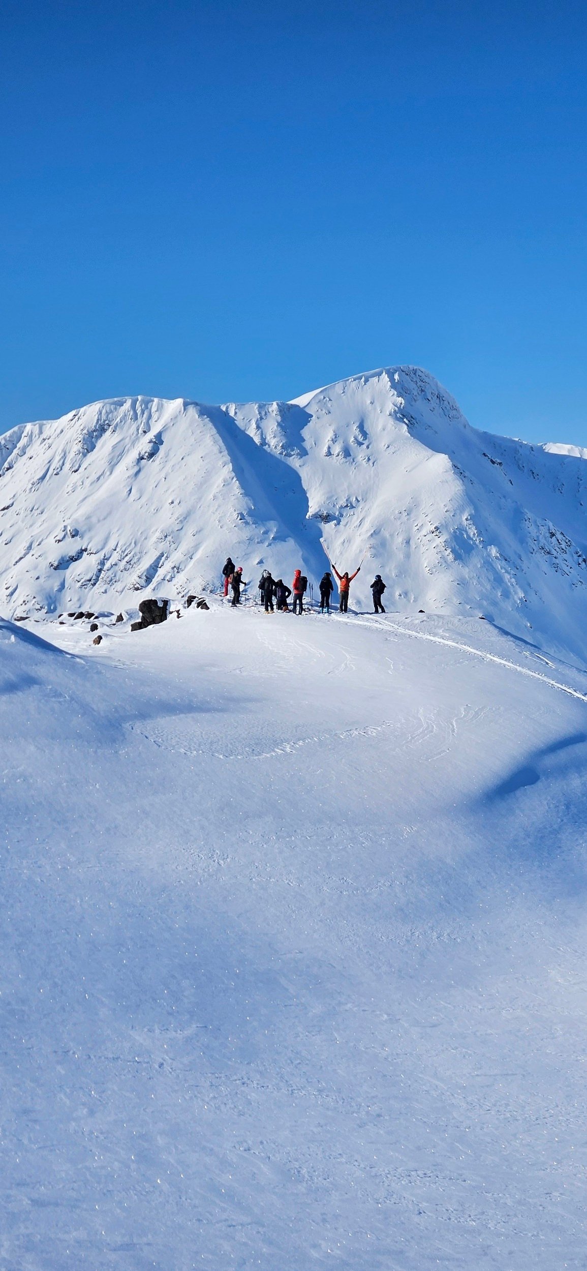 Group of skiers on top of a slope in Northern Norway