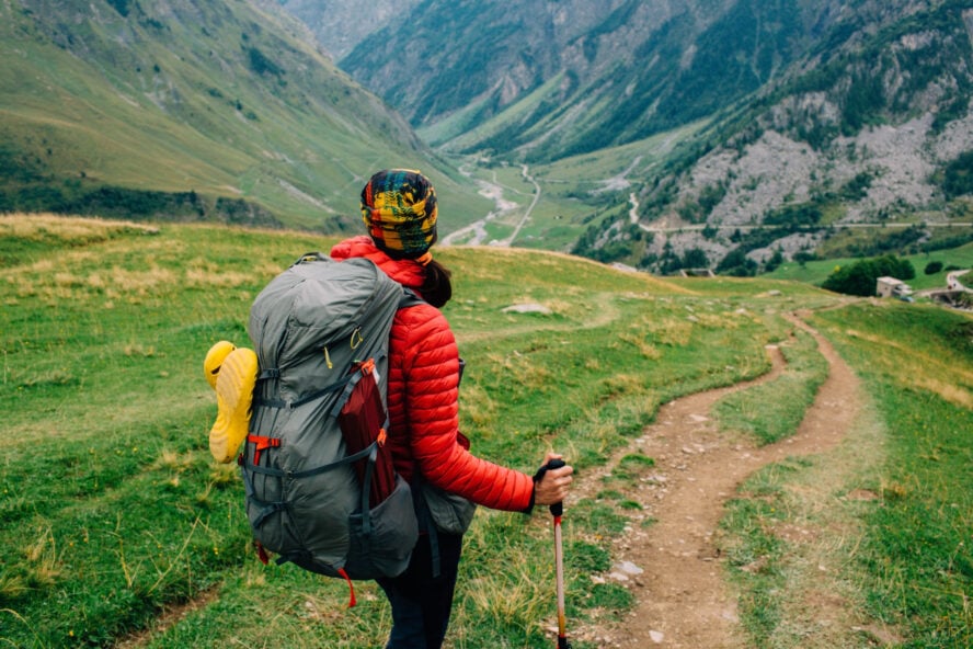 Hiker with a backpack, looking on valley near Chapieux . Hiking around Mont Blanc