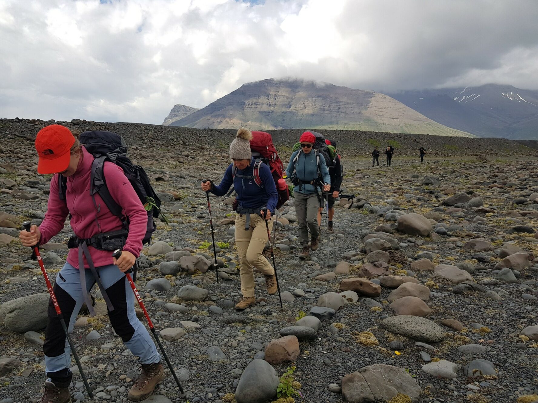 Hikers navigating rugged terrain in the Icelandic wilderness.