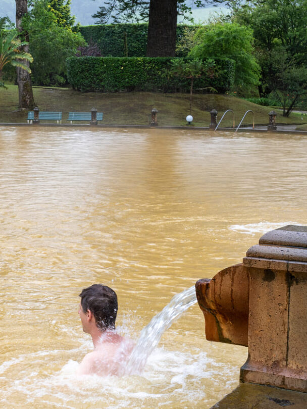 Hiker in a red jacket at the caldera on São Miguel island in the Azores