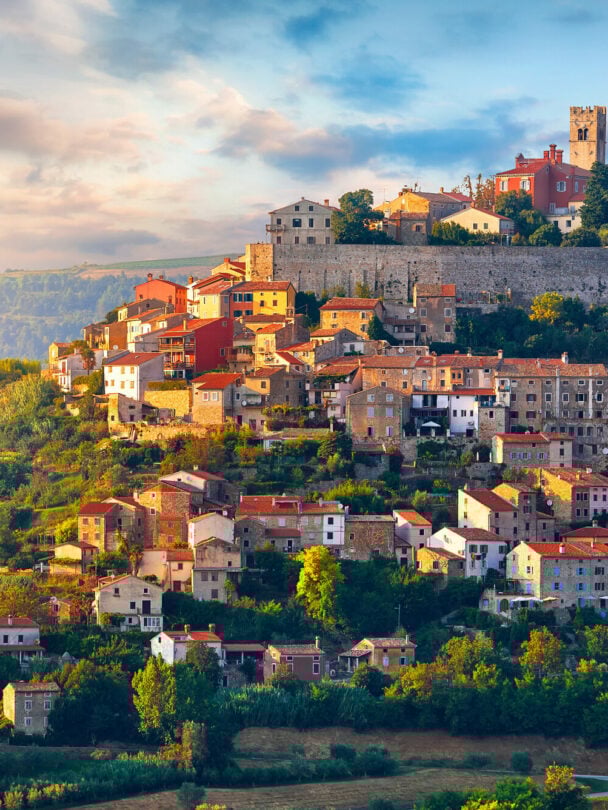 A cyclist pointing at the medieval hilltop town of Motovun while located in the verdant Mirna Valley in Istria, Croatia.