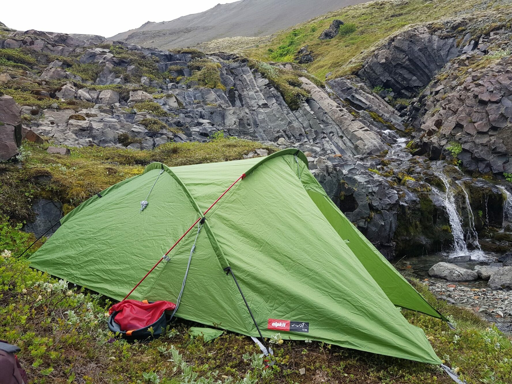 A tent pitched near a small waterfall, in tIceland’s Highlands.