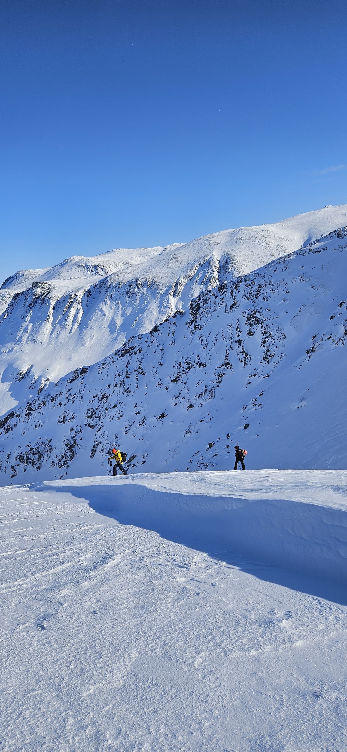 Two skiers on a slope above fjord in Norway