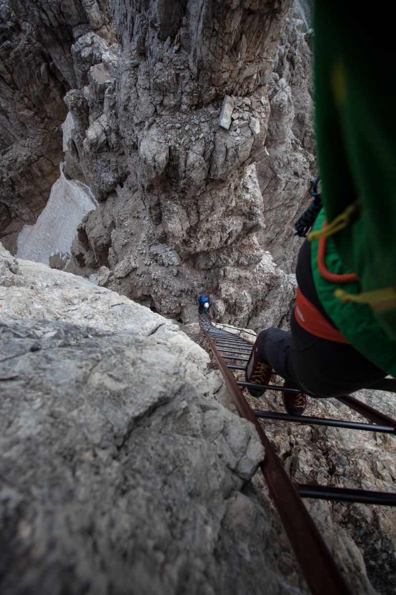 Via ferrata enthusiasts climbing a ladder in the Bochhette Alte via ferrata, Dolomites