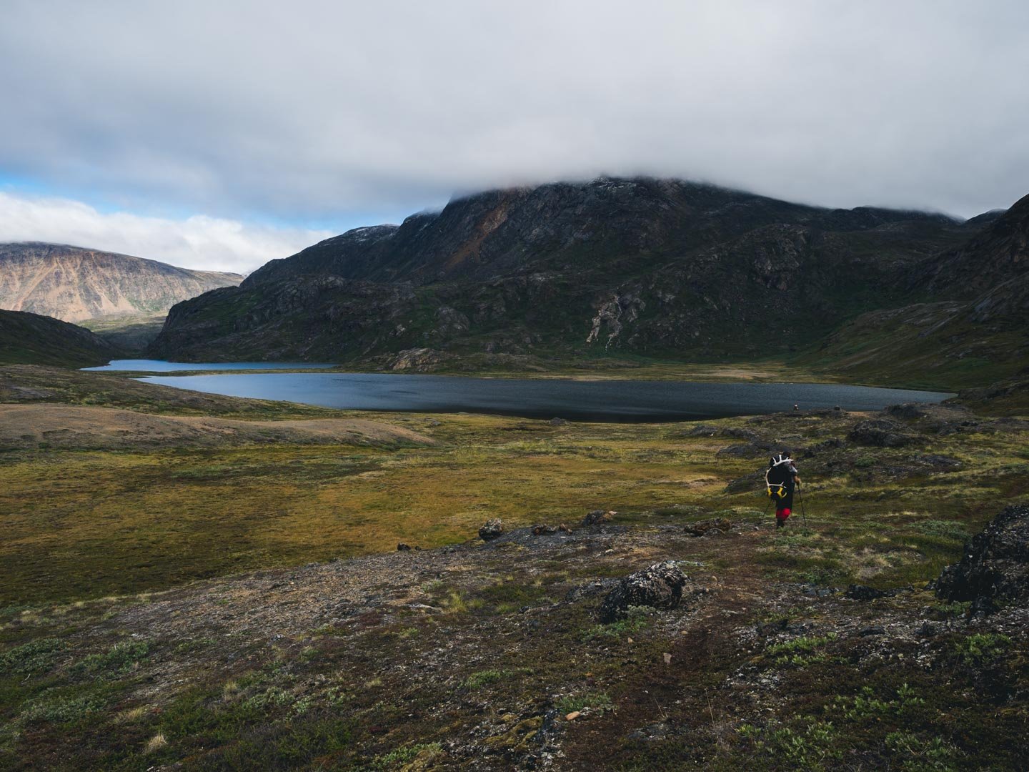 Hiker passing by a lake in Greenland