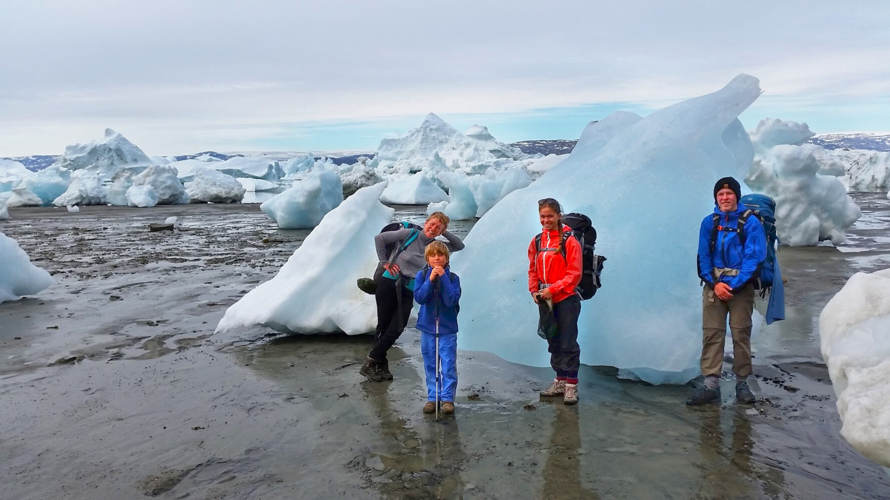Hikers trekking amongst Greenland icebergs