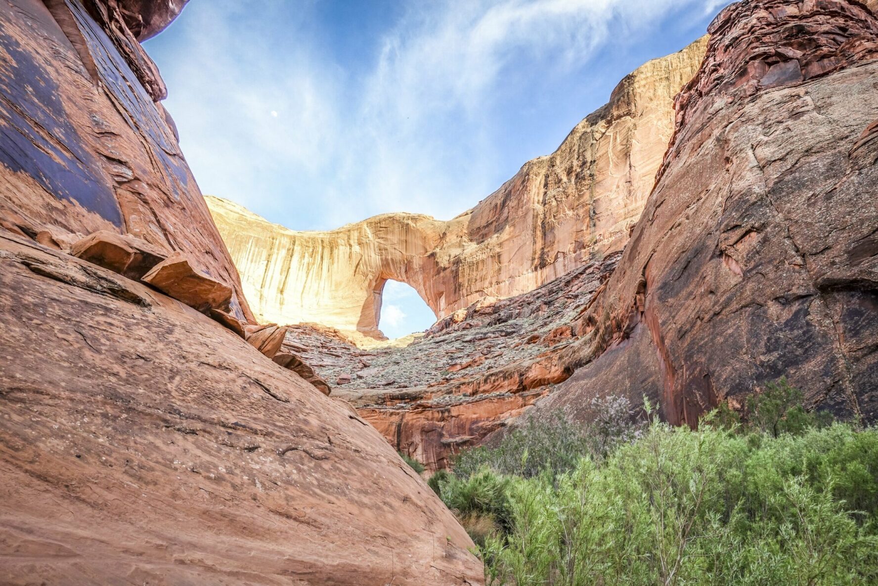 Layered sandstone rock formations and an arch in Coyote Gulch, Escalante, Southern Utah.
