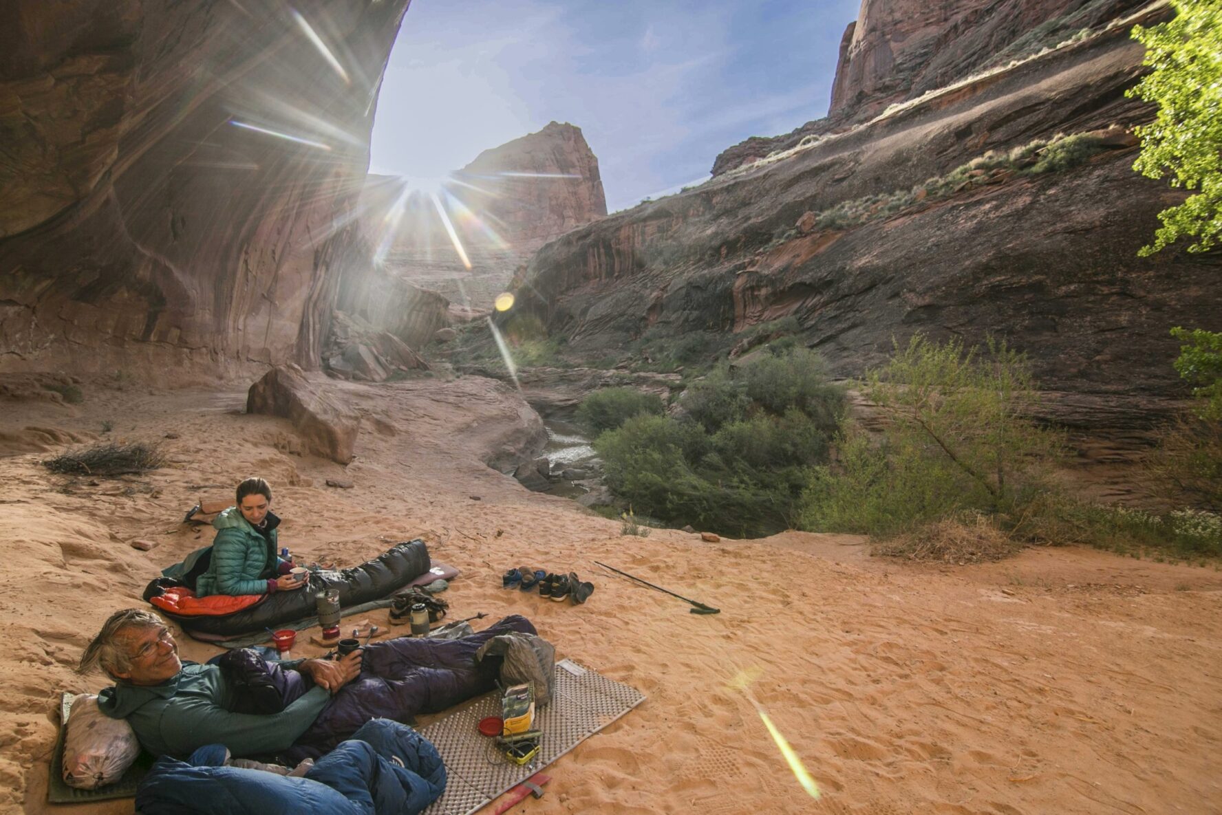 Backpackers lying down and enjoying themselves amidst gorgeous Coyote Gulch landscapes.