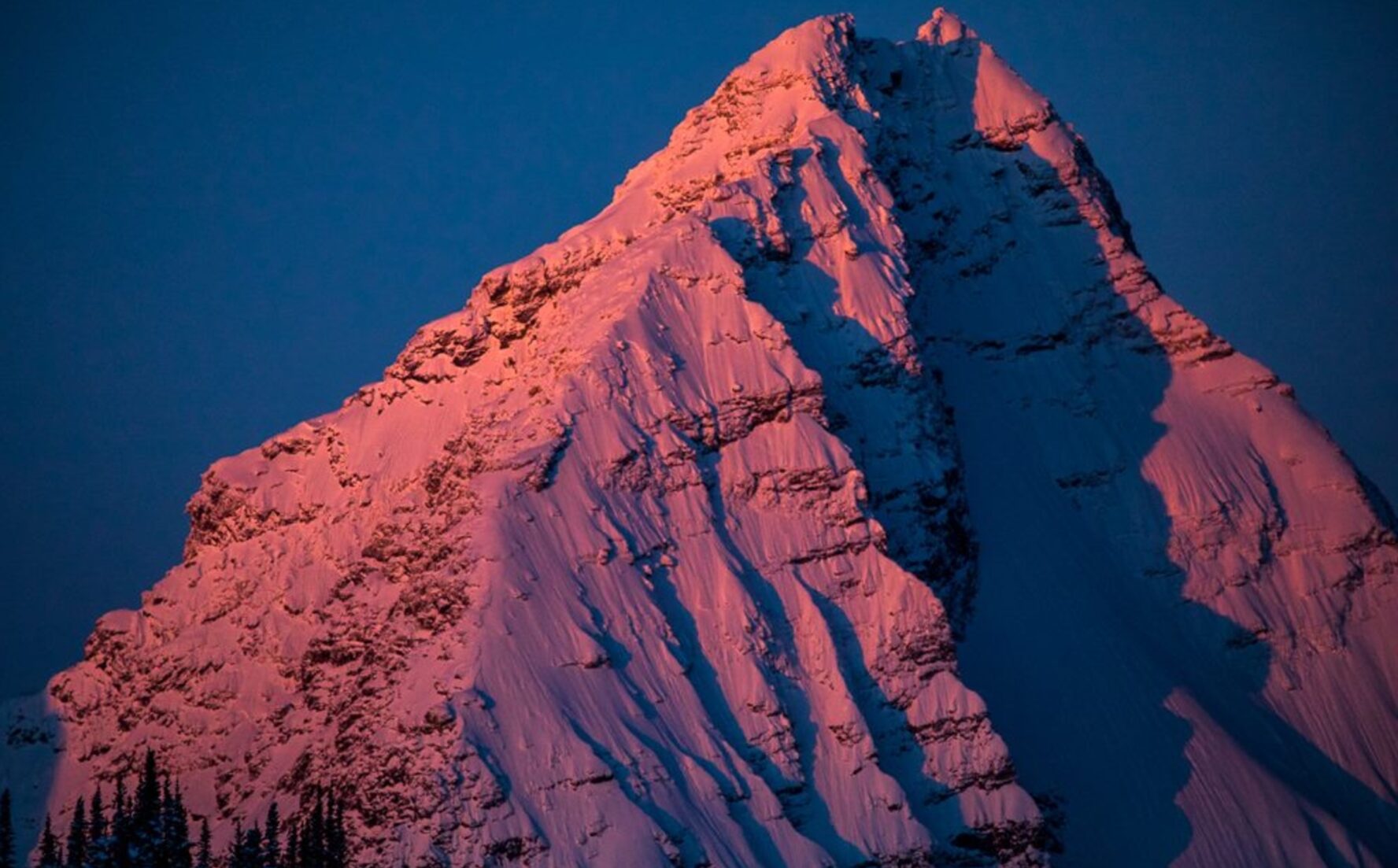 Snow-covered mountain face at sunset, in British Columbia.