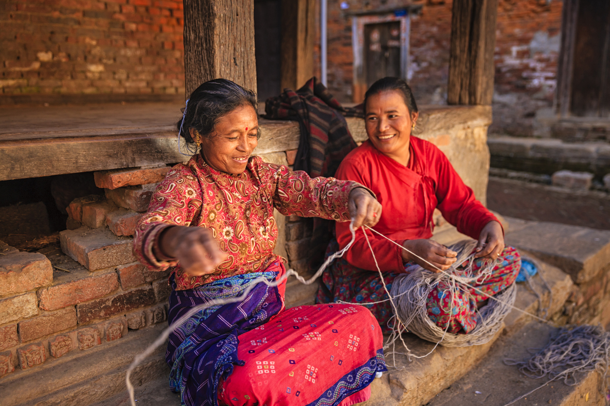 Nepali women spinning a wool in front of the house. Bhaktapur in Kathmandu valley. Nepal.http://bem.2be.pl/IS/nepal_380.jpg