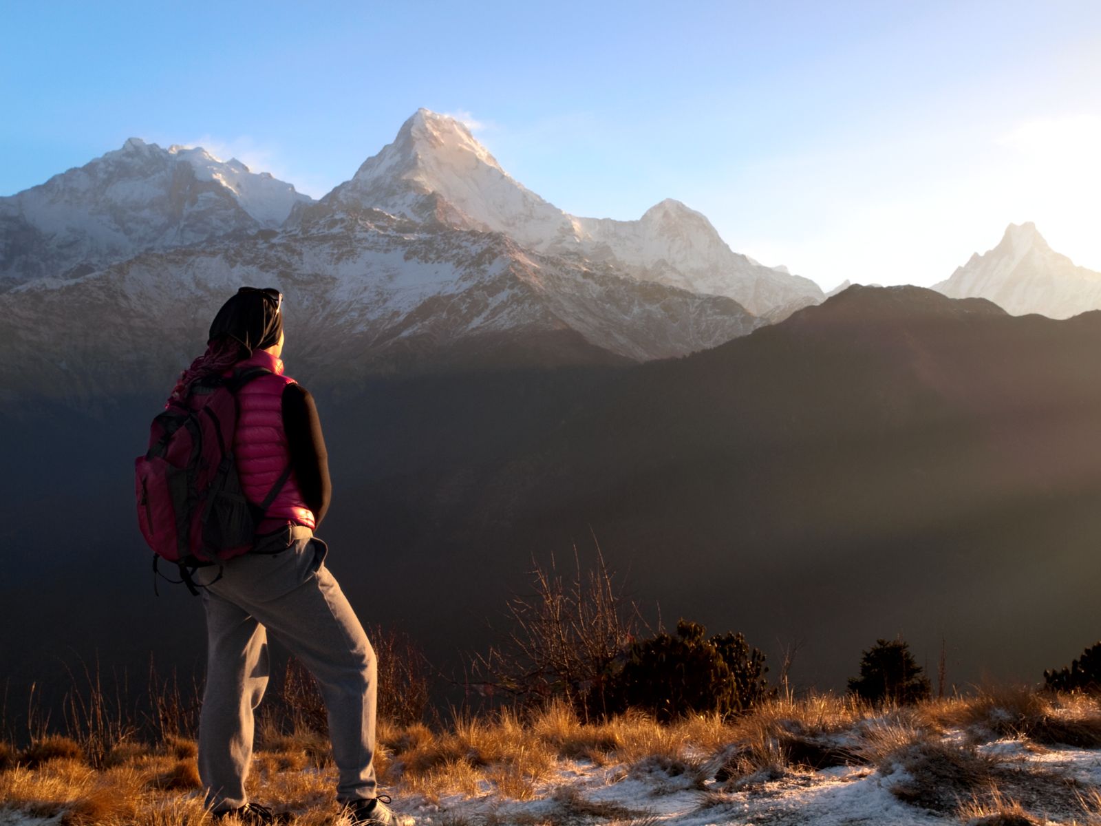 Annapurna Base Camp Trek hiker admiring the sunrise view of snow-capped mountains from Poon Hill.