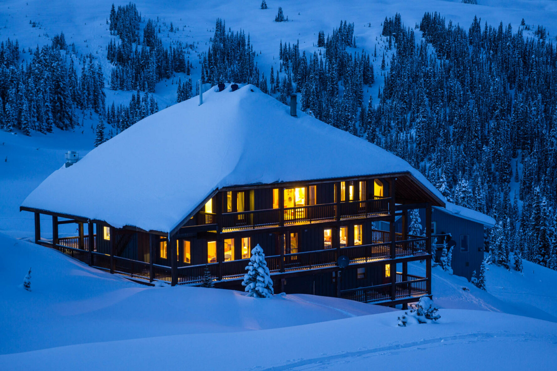 Purcell Mountain Lodge, a backcountry lodge in British Columbia, at dusk, during winter.