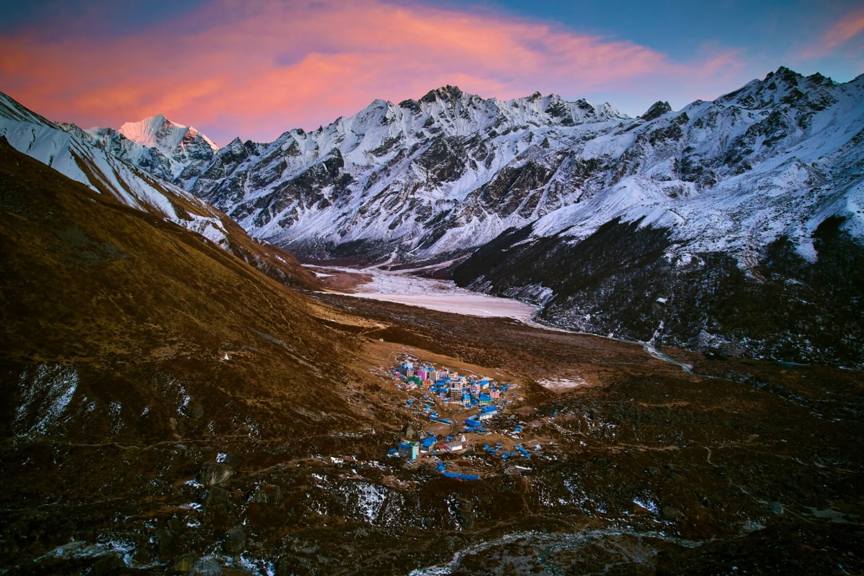 A bird-eye’s view of the Nepalese Langtang Village, surrounded by Himalayan peaks, during sunset.