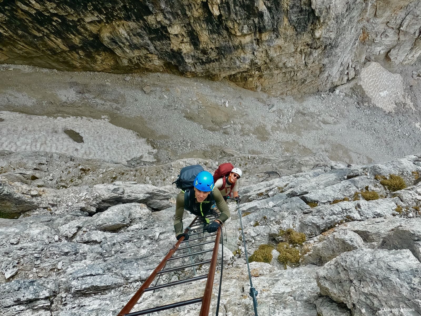 A via ferrata practicer climbing a ladder on via delle Bocchette in the Dolomites.
