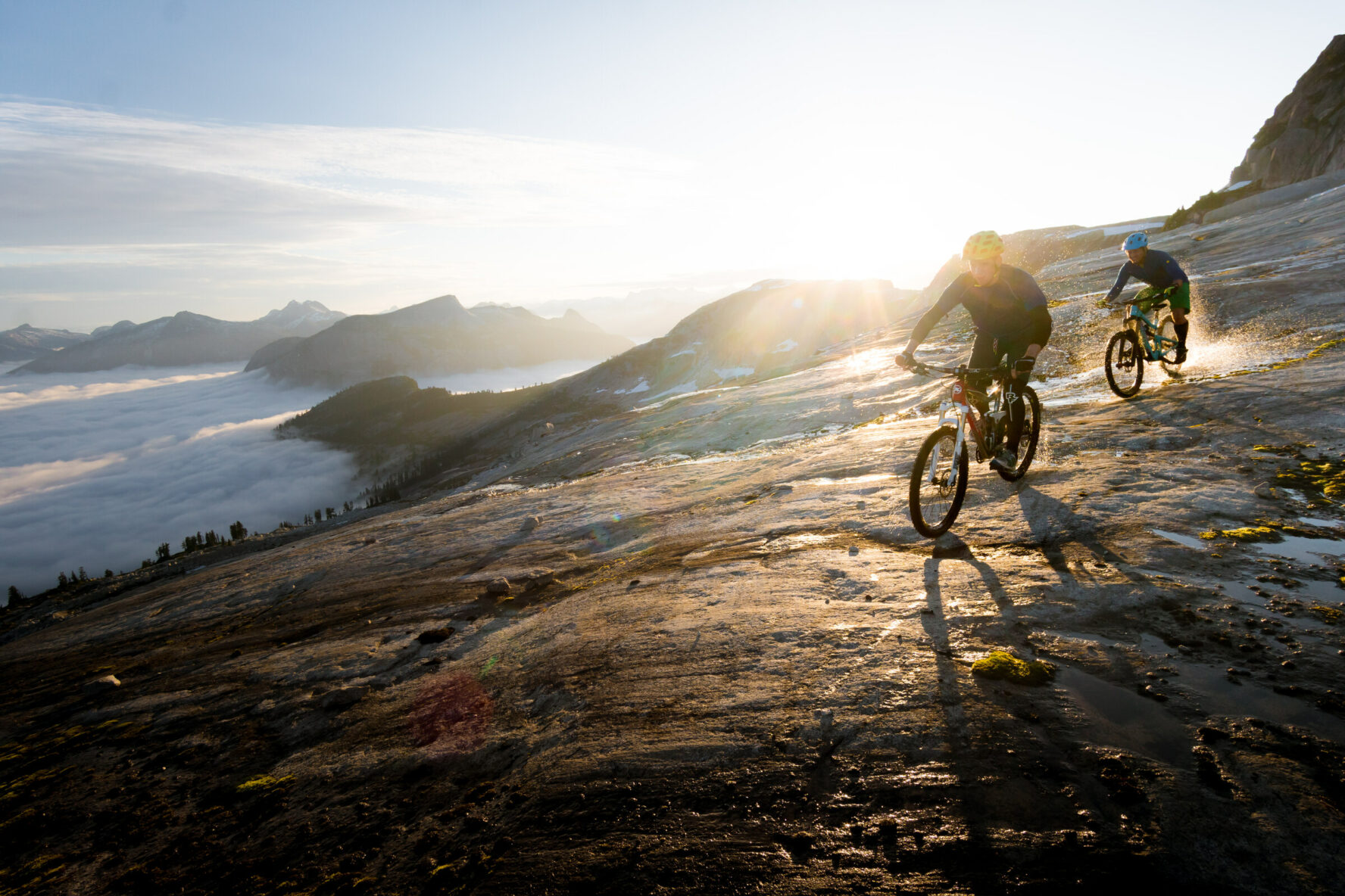 Mountain biker riding a trail above the clouds in BC’s Coast Mountains.