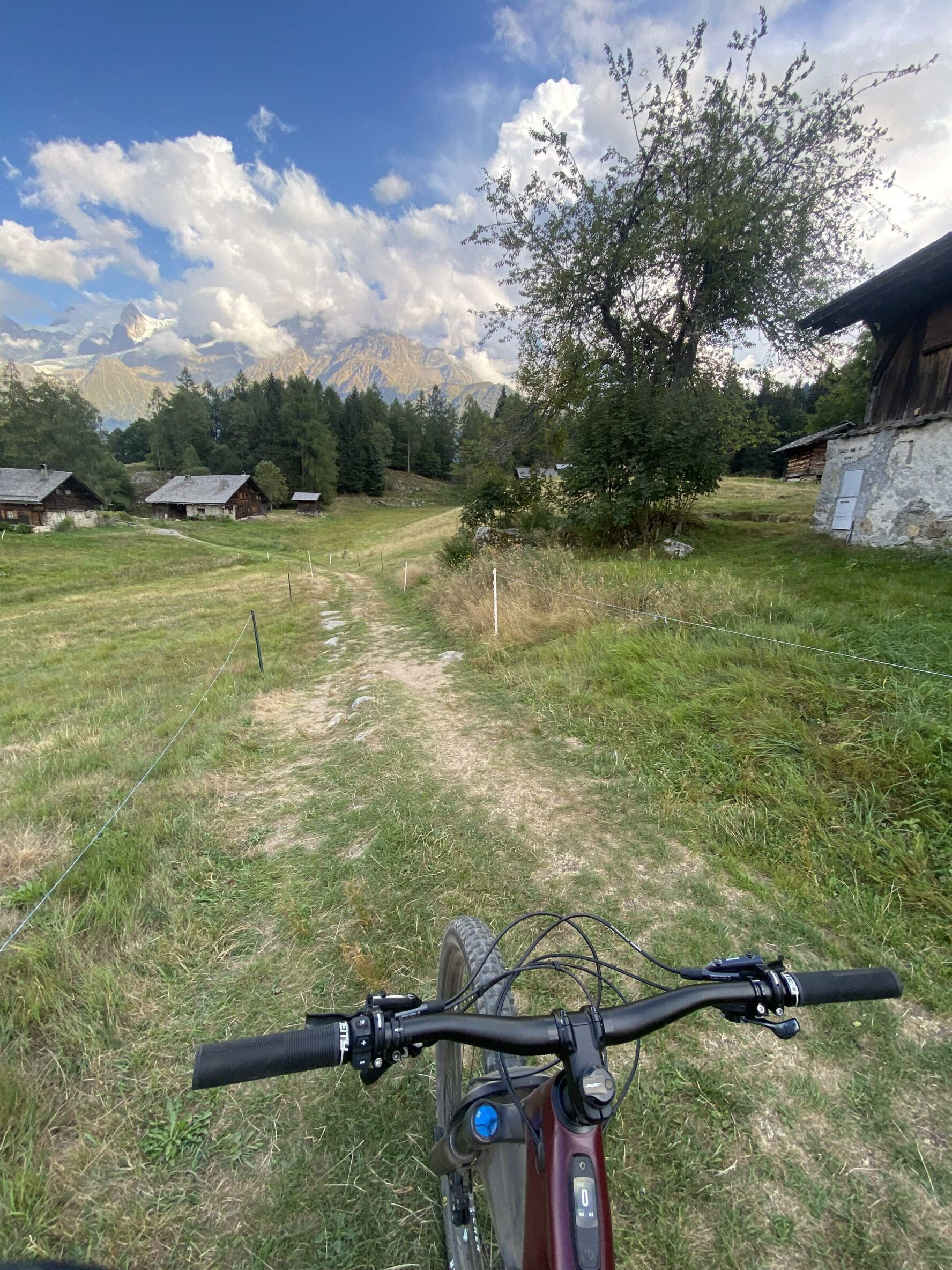 POV of a mountain biker riding through an Alpine pasture in the Chamonix area.