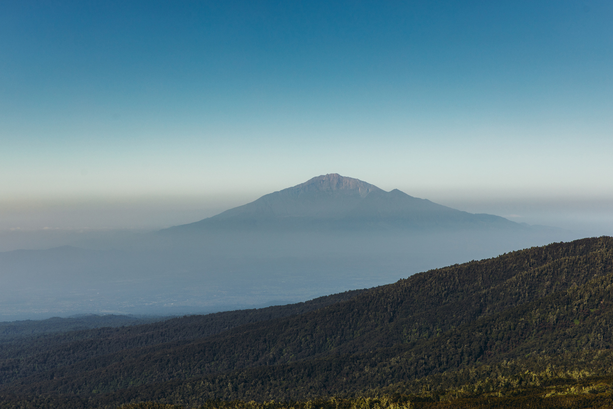 Scenic view of mount Meru and the green valley during sunny day in Kilimanjaro National park
