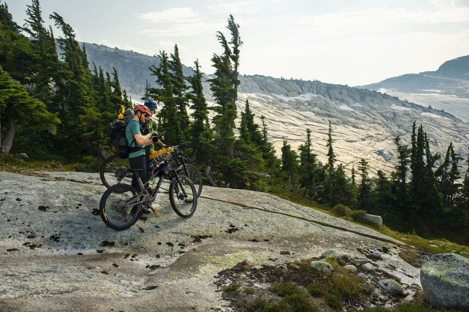 Mountain bikers taking a break and enjoying the views of the incredible Coast Mountains, BC, Canada.