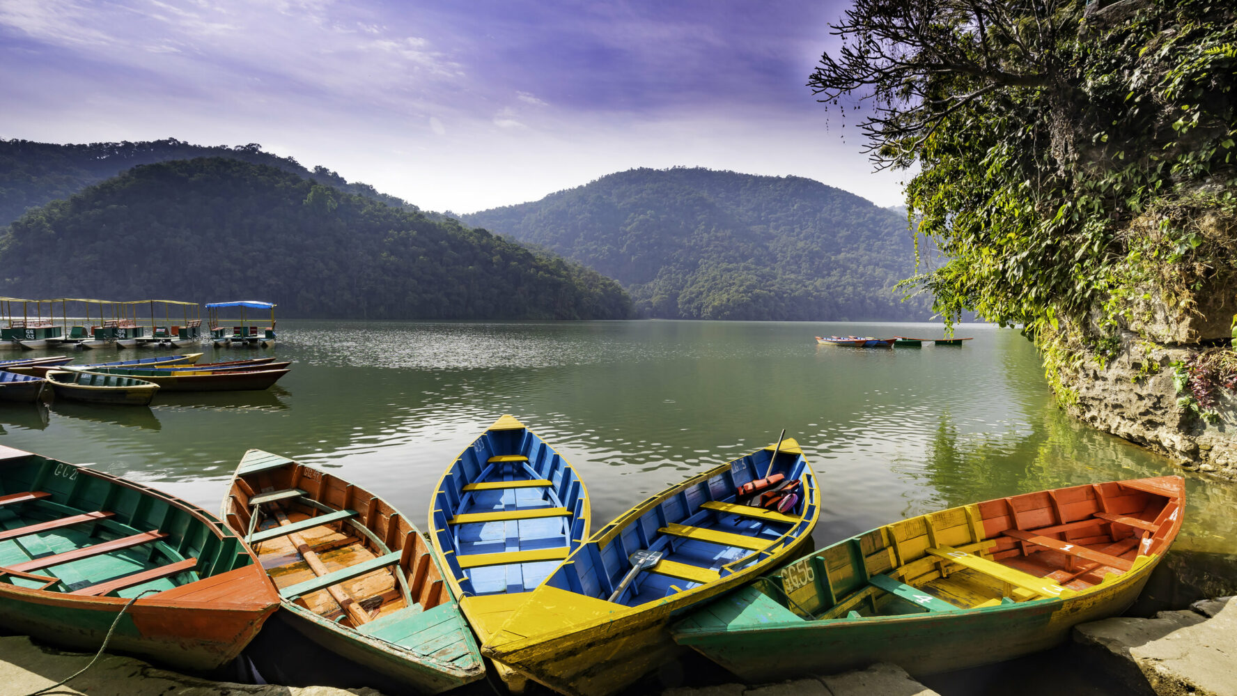 Phewa lake in Pokhara, Nepal, with small colorful boats.