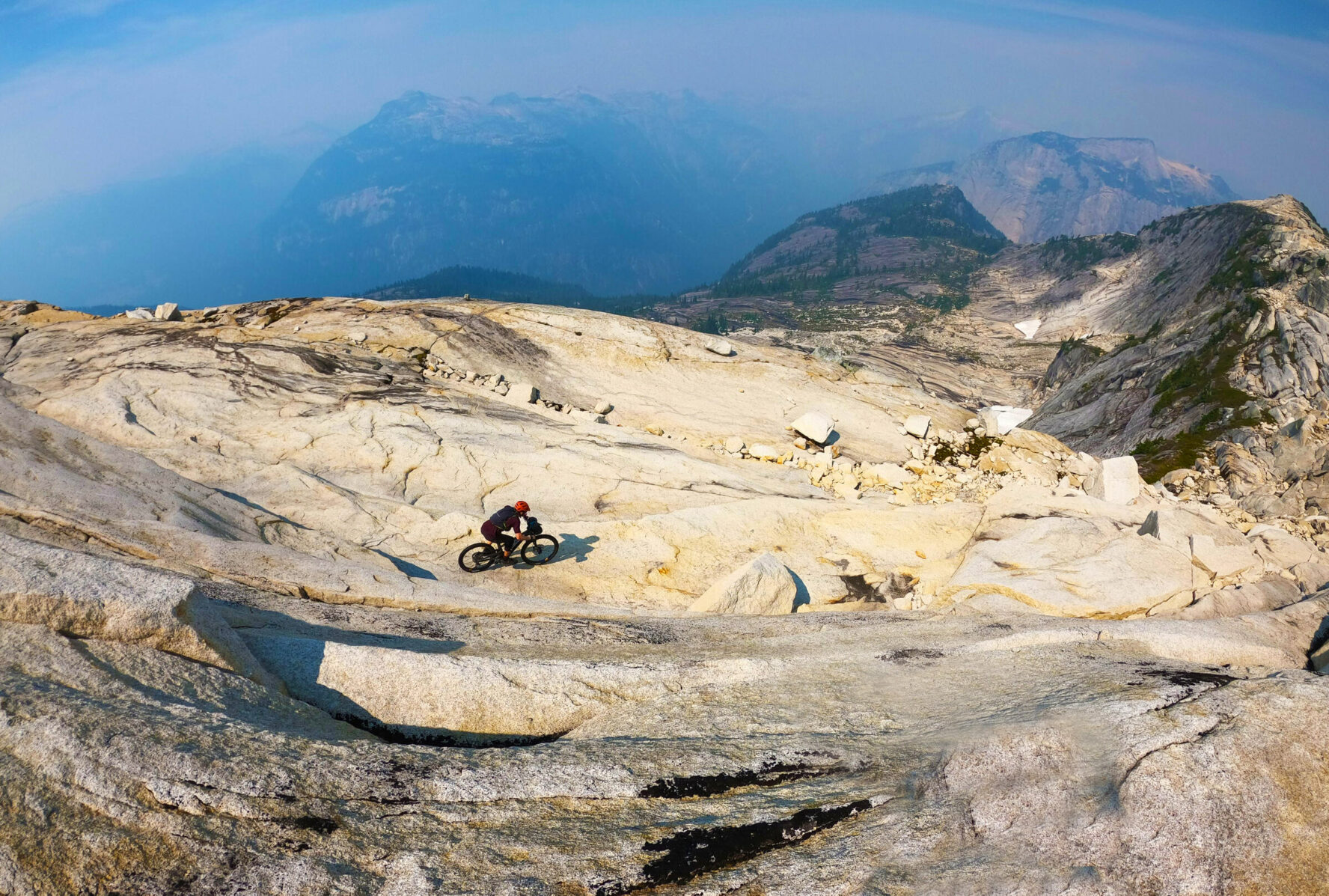 Mountain biker approaching a ridge during a descent in the Coast Mountains, BC.