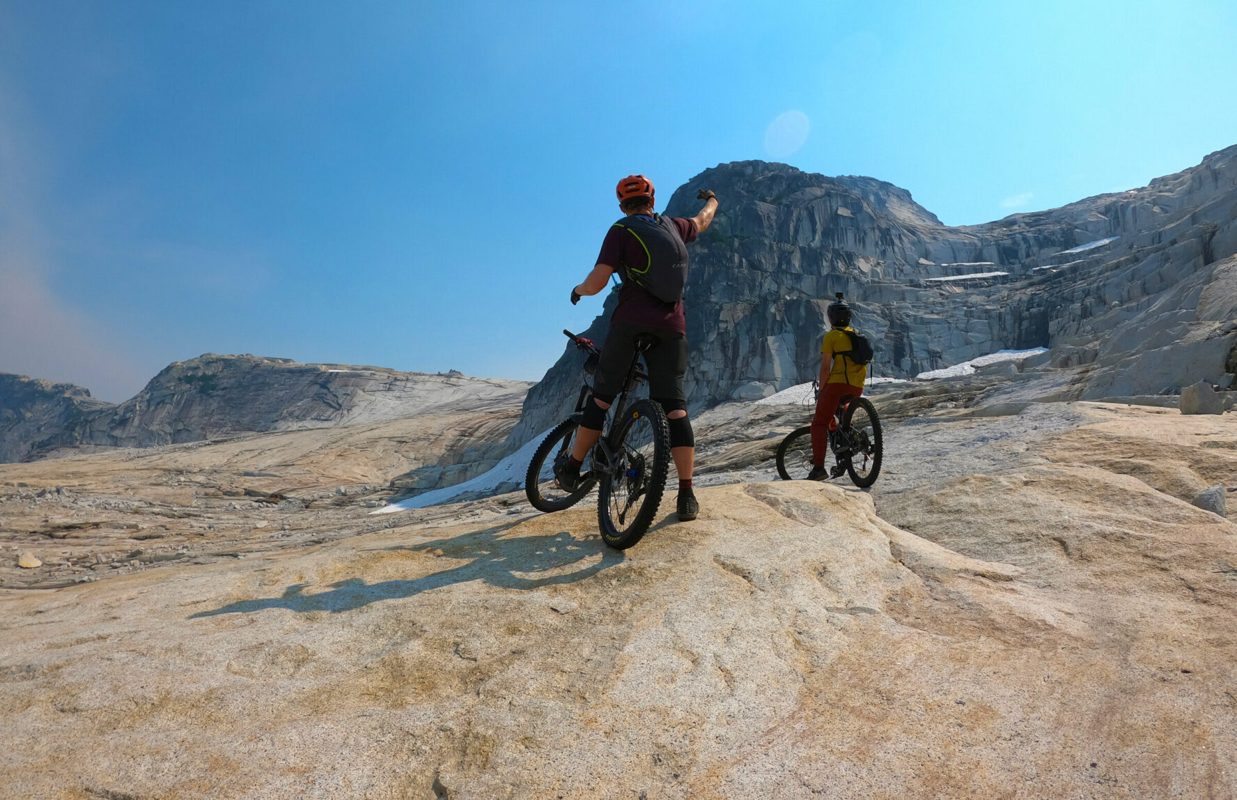MTBers looking at interesting rock formations in the Coast Mountains, while on their heli-accessed MTB trip.