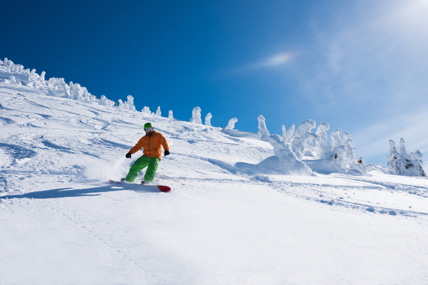 Snowboarder on top of a powder-laden slope in Revelstoke, BC.