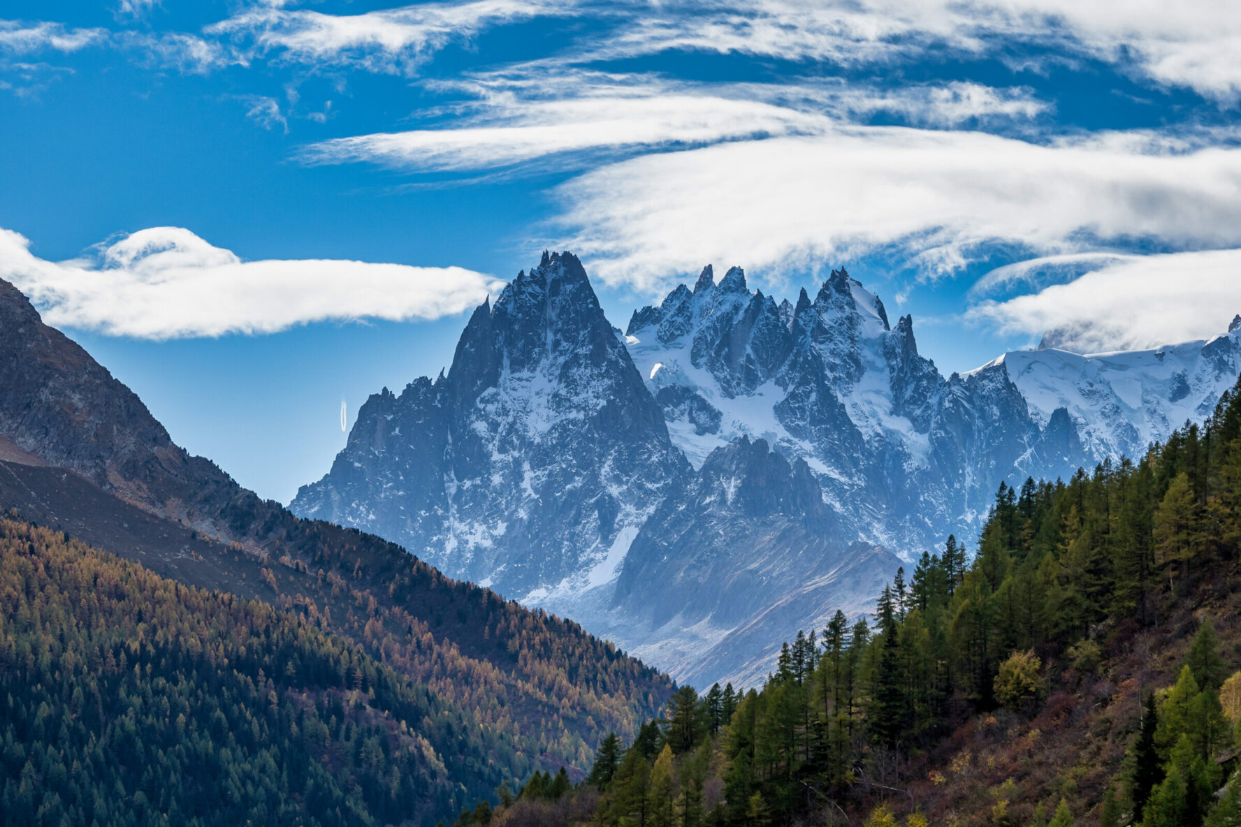 View of sharp Alpine peaks rising from the forested valley, Vallorcine, Chamonix area, France.