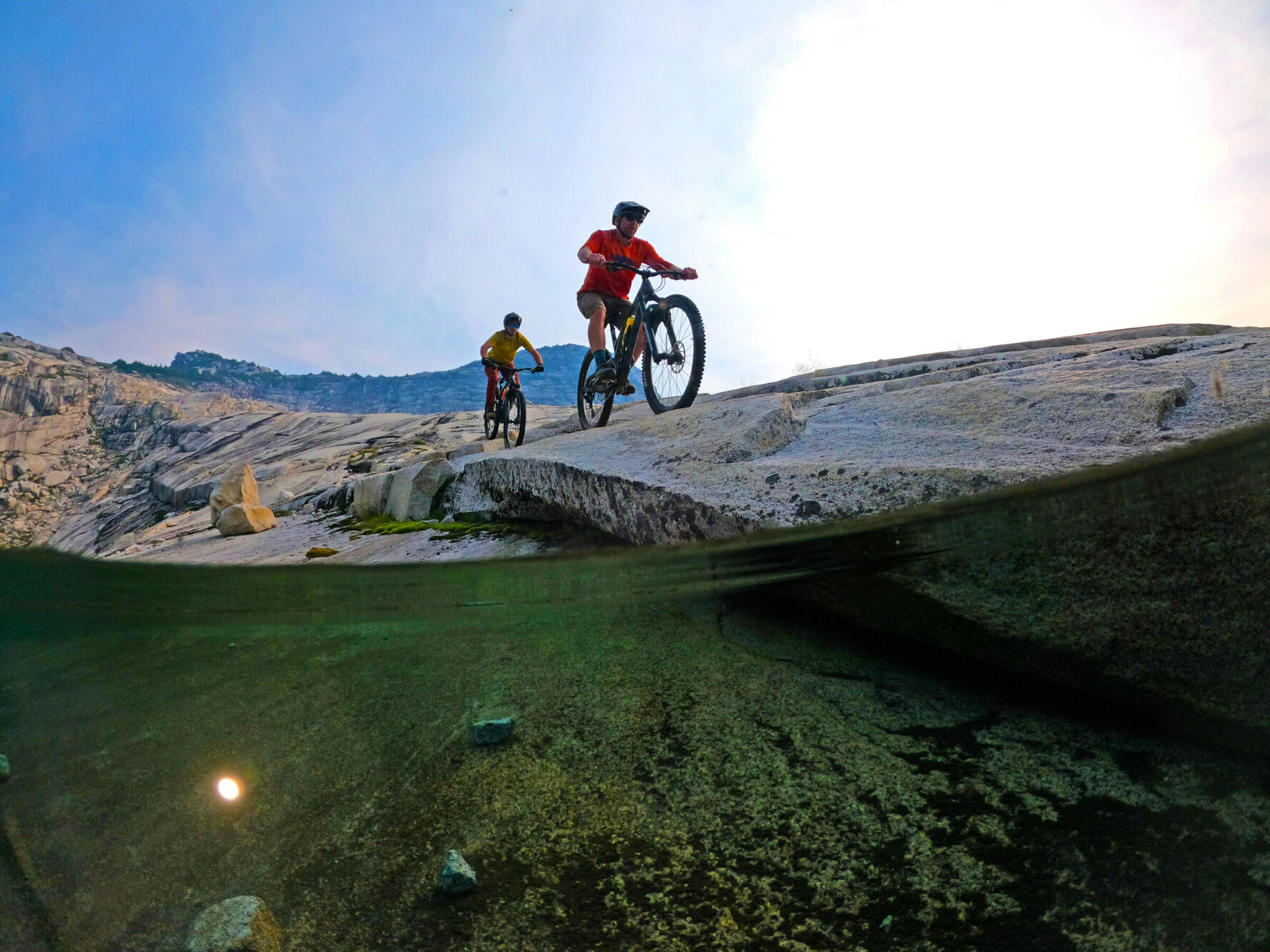 MTBers riding right near the water surface, Coast Mountains.